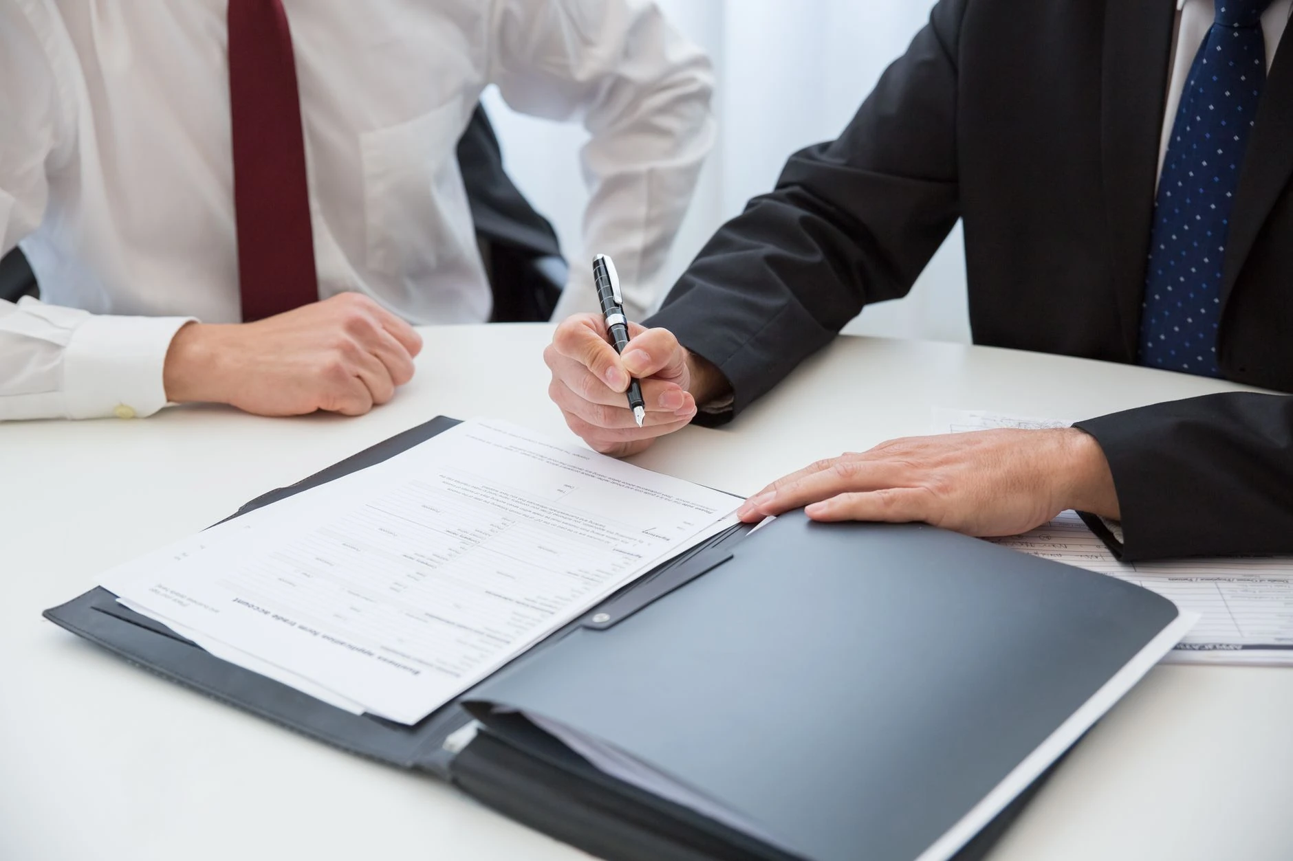 Deux professionnels signant un contrat en bureau formel — Formation IA pour expert en recouvrement