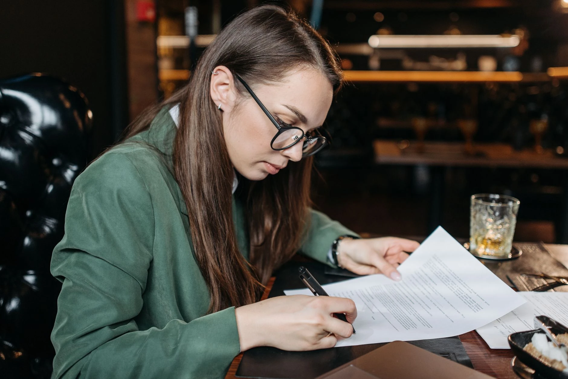 Professionnelle en tenue formelle relisant des documents de marché public — Formation IA pour responsable appels d'offres